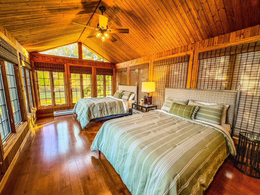 Un letto queen-size in una camera condivisa con due letti queen-size e bagno in comune in una moderna casa sul lago