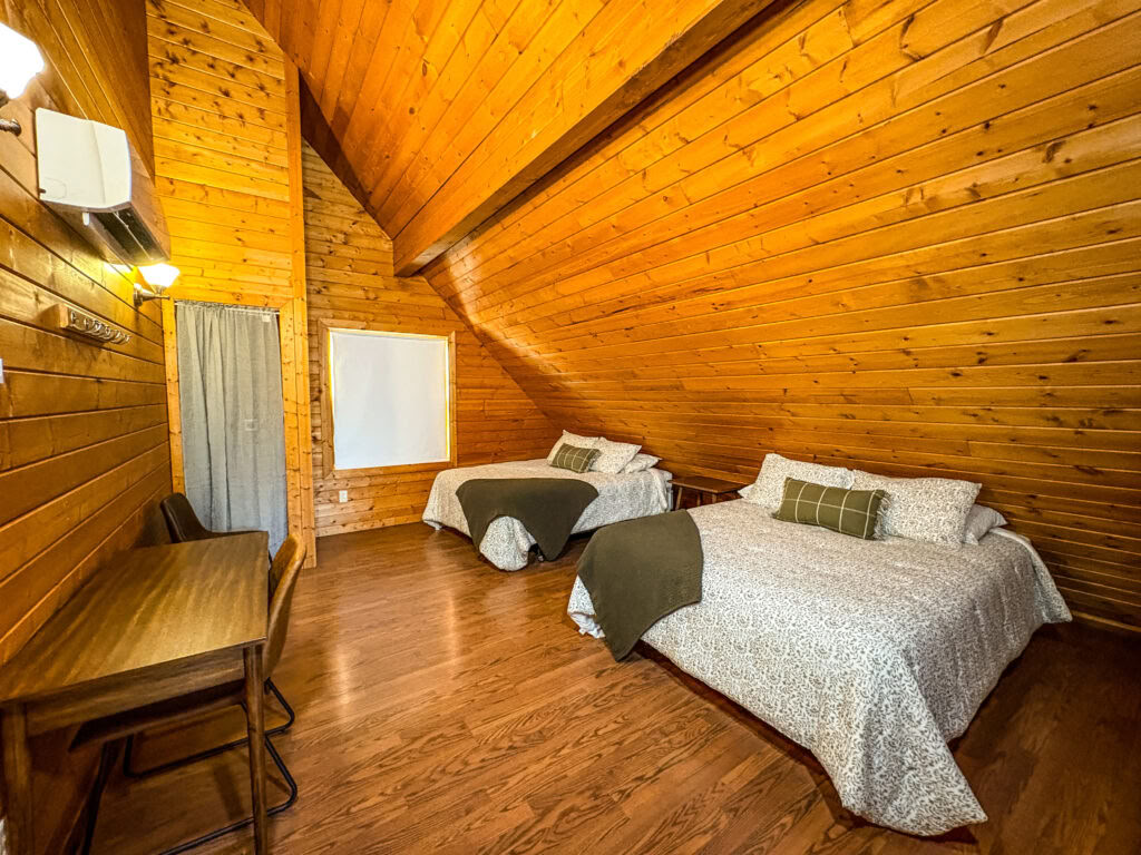 Un letto loft queen in una cabina loft condivisa con due letti queen e bagni in comune